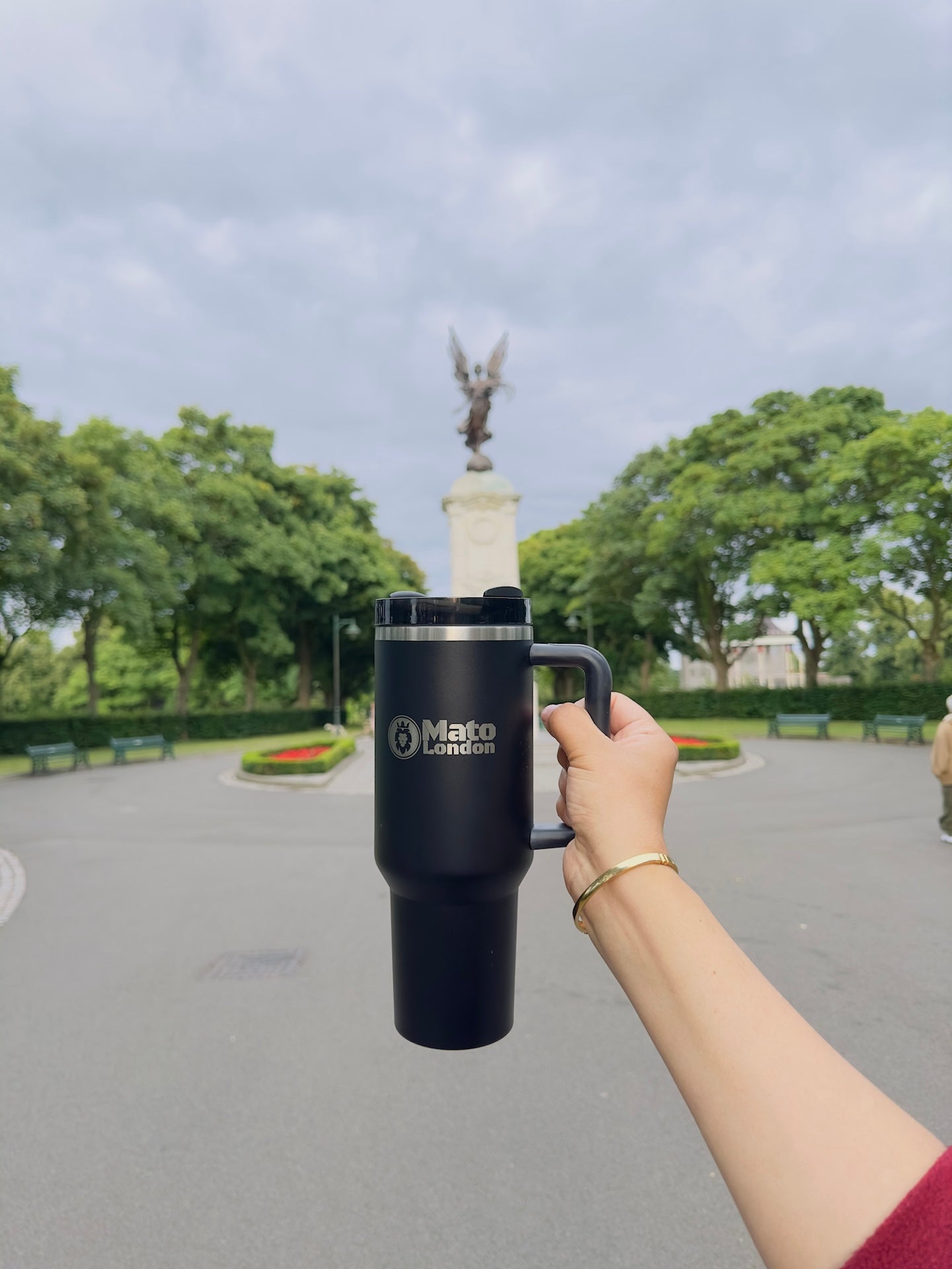 Woman holding Mato London black 40oz insulated tumbler 
outdoors in park — leakproof stainless steel travel cup UK